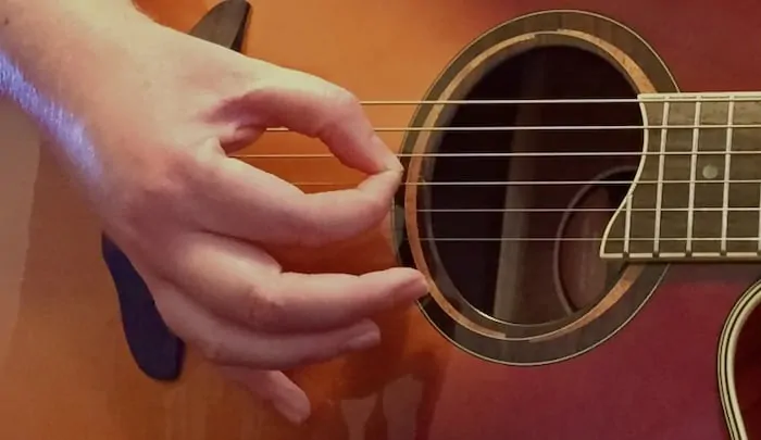 using fingers to strum guitar